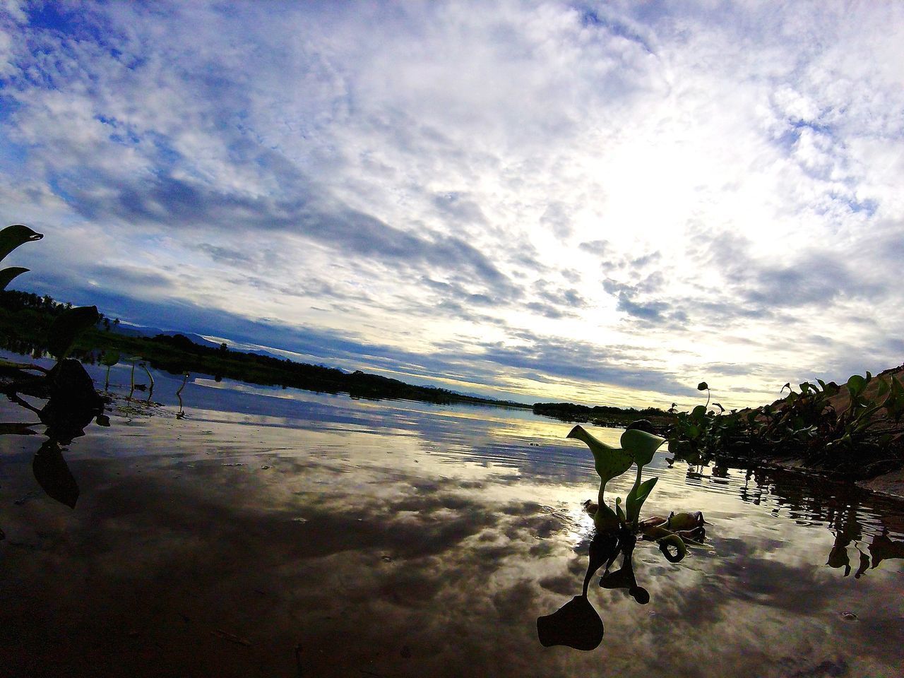 REFLECTION OF MAN ON LAKE AGAINST SKY