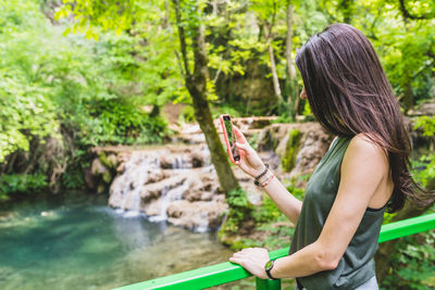 Woman using mobile phone in water