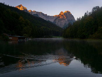 Scenic view of lake and mountains against sunrise