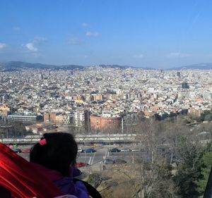 Rear view of woman in city against sky