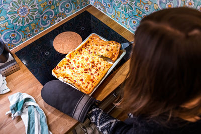 High angle view of mid adult woman preparing food on table at home