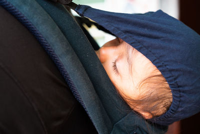 Midsection of person carrying sleeping girl