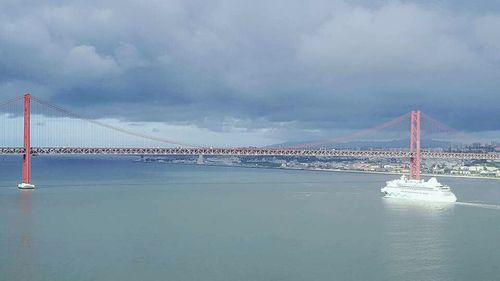 Bridge over river against cloudy sky