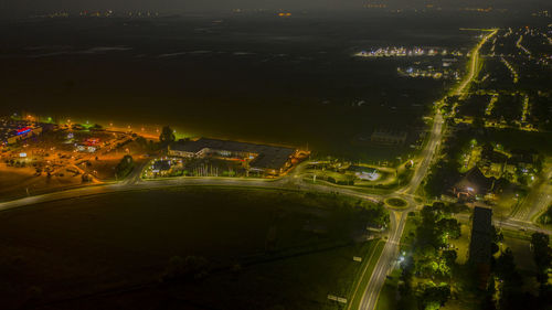 High angle view of illuminated street amidst buildings at night