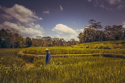 Man standing on field against sky