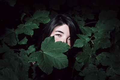 Portrait of woman amidst tree at night