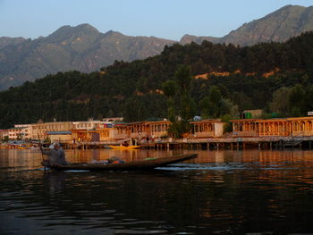 Boats sailing on river by mountains