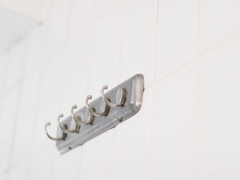 Old and dirty with a little rust and mold metal hanger on a tiled white wall