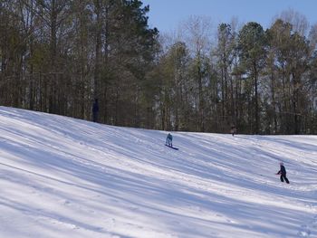 Person skiing on field against sky during winter