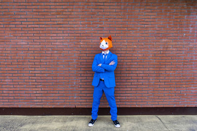 Full length portrait of person standing against wall