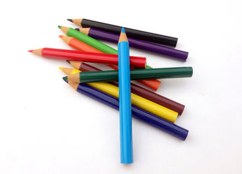 High angle view of colored pencils on white background