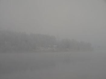 Scenic view of landscape against sky in foggy weather