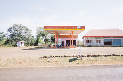 Built structure on field by house against sky