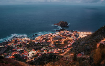 High angle view of buildings by sea against sky