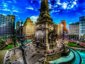 Statue of liberty in city against blue sky