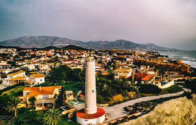 High angle view of townscape by sea against sky