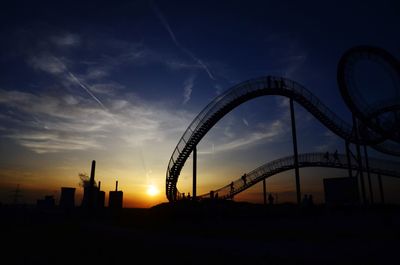 Silhouette of ferris wheel at sunset