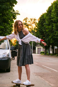 Full length of woman standing against car