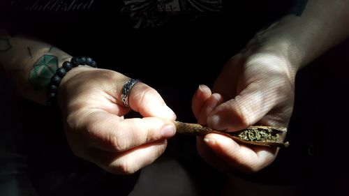 Close-up of man hand rolling marijuana joint