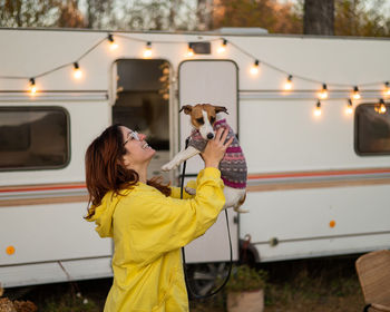 Portrait of young woman with dog on road at night