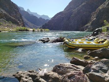 Inflatable rafts on riverbanks by mountains