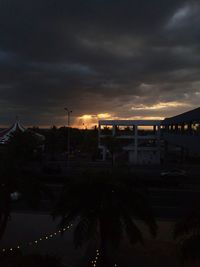 Illuminated city against sky at sunset