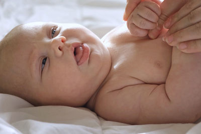 Mother giving massage to little child infant.  female hands massaging to newborn.  cream, body care