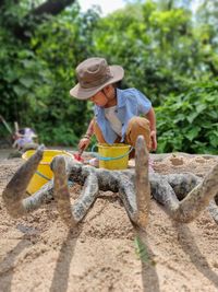 A kid pretends to dig dinosaur bones in th ground