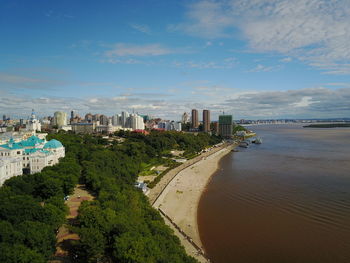 Scenic view of beach by buildings against sky