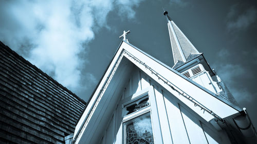 Low angle view of modern building against cloudy sky