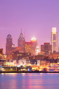 Illuminated buildings in city against sky at night