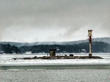 Built structure by water against sky