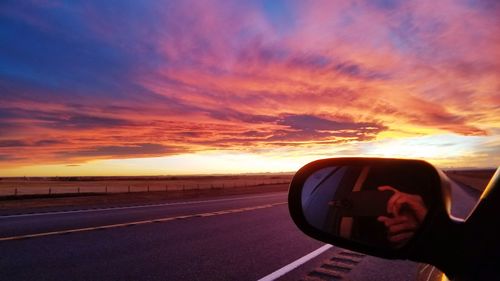 Man driving car against sky during sunset