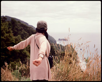 Rear view of man looking at camera against sky