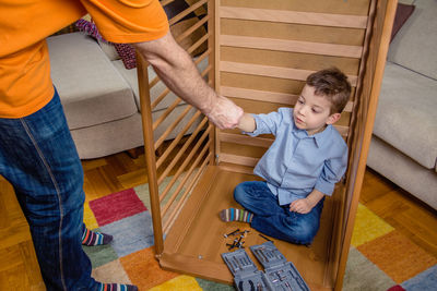 High angle view of siblings sitting on floor at home