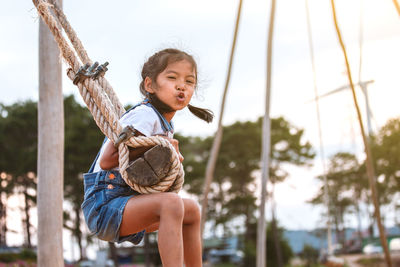 Side view of girl swinging at playground