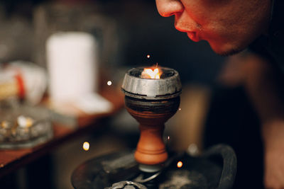 Close-up of man holding burning candle