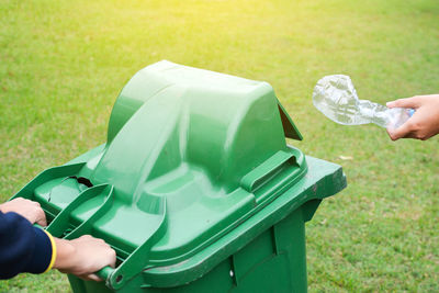 Volunteers with garbage bin cleaning grassy field