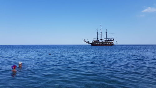 Scenic view of sailboat in sea against clear sky