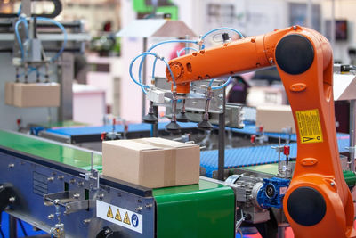 Robotic or robot arm in automated factory packing system for efficient industrial box handling