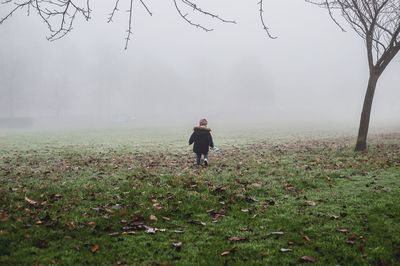 Rear view of man on field against sky