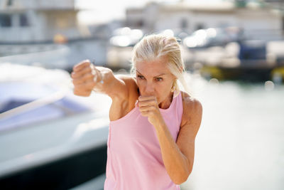 Portrait of woman kickboxing outdoors