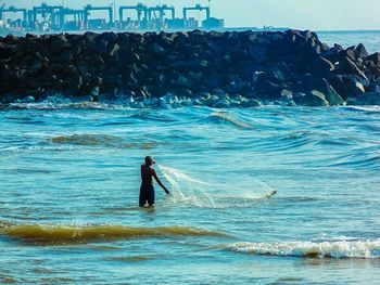 Silhouette of people surfing in sea