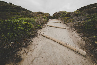 Road amidst land against sky