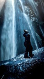 Person standing by gljufrafoss on rock