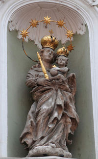 Low angle view of angel statue against wall