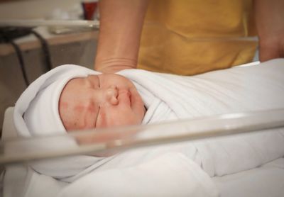 Midsection of baby sleeping in bed