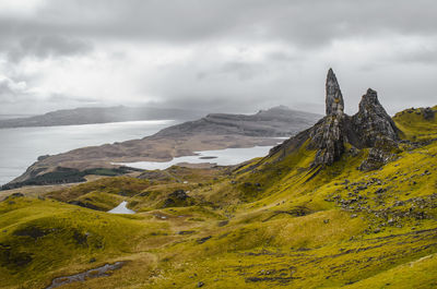 Scenic view of old man of storr against cloudy sky