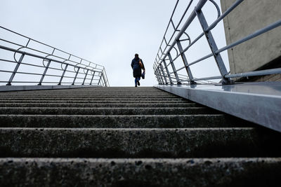 Rear view of man walking on staircase