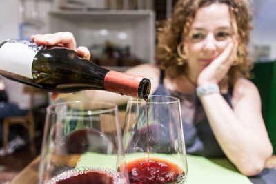 Woman pouring wine in glasses